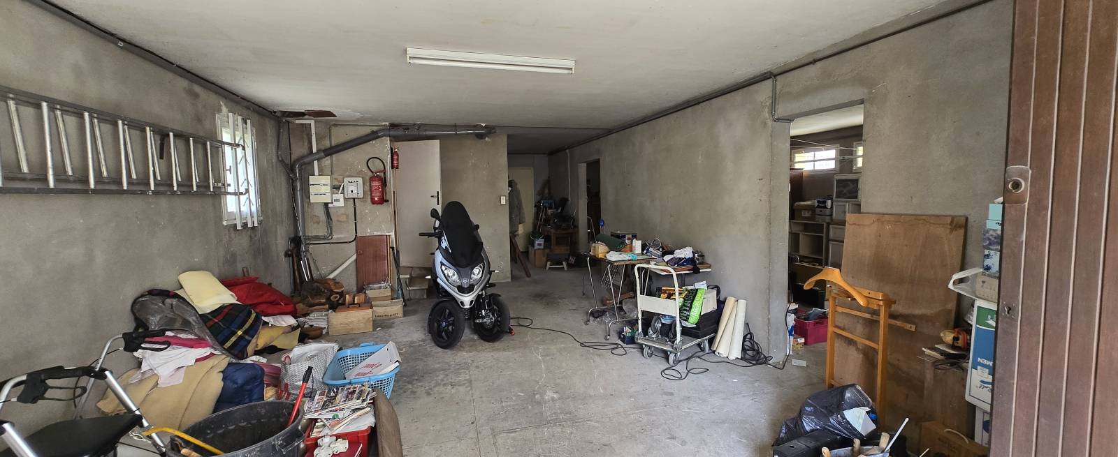 Grand espace d'environ 120 m², actuellement utilisé en garage, pouvant être transformé en espace habitable